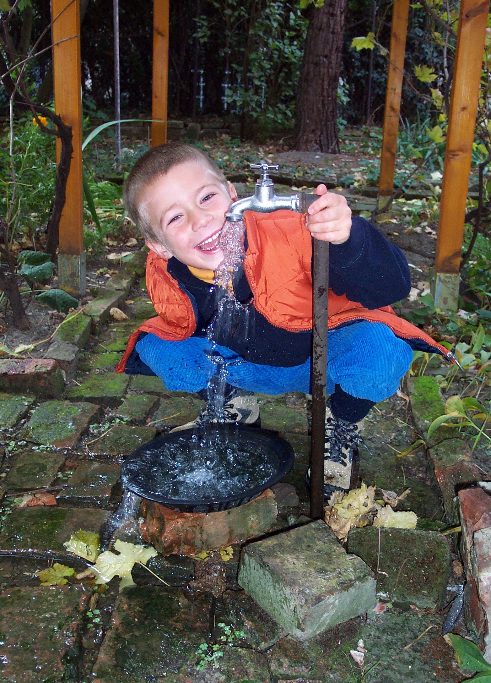 Kind bei der Wasserleitung